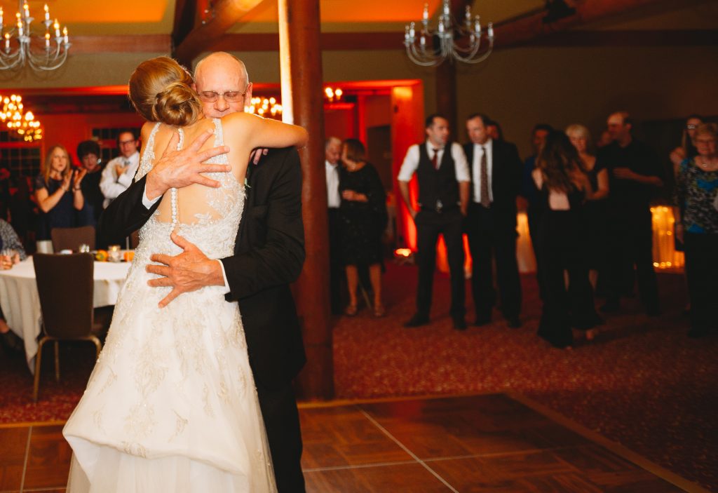 Wedding photo of bride and father embracing